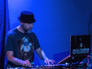 Ein Mann mit Hut spielt ein DJ-Set.